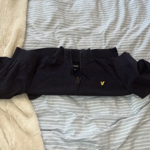 Mörkblå half zip tröja från Lyle & Scott - Storlek s-m passar både s och m. Köpte för 1200kr nypris och har använt den många gånger men finns inget tecken på användning. Snygg mörkblå stickad tröja från Lyle & Scott med half zip och långärmad design. 