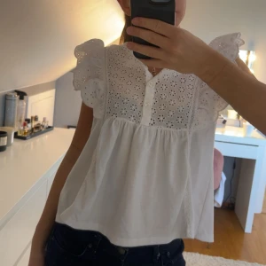Vit blus med volangärmar från Mango - Supersöt vit blus från Mango med broderade blommor och knappar framtill! 