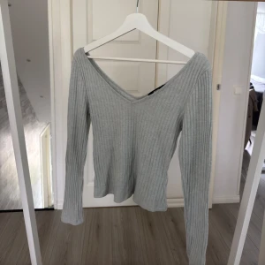 Ljusgrå ribbad långärmad tröja - Säljer en ljusgrå ribbad tröja från Bik Bok med v-ringad hals och lång ärm. Tröjan har en slim passform och är tillverkad i mjuk bomullsmix som är skön mot huden. 