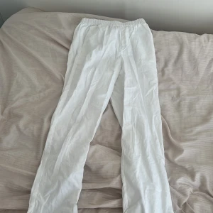 Vita linnebyxor med resårmidja - Säljer ett par fräscha vita linnebyxor med skön resår i midjan. Byxorna har raka ben och en enkel, clean look som passar perfekt till chill dagar. Materialet är lätt och luftigt linne, vilket gör dem riktigt nice under varmare månader.