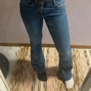 Blå bootcut jeans från ONLY XS - Säljer ett par blå jeans från ONLY i storlek XS med bootcut passform. Jeansen har klassisk femficksdesign, dragkedja och knapp framtill samt bälteshällor. Snyggt mediumblå tvätt och sköna att bära. Perfekt för dig som gillar retrovibbar och vill ha lite utsvängda ben.