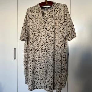 Beige leopardmönstrad klänning M - Säljer en beige kortklänning med svart leopardmönster från The Black Label Collection. Klänningen har korta ärmar, knappar framtill och en loose passform + FICKOR!!! ;) passar även L-XL.