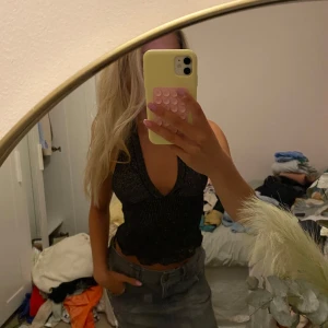 Glittrig svart topp - Säljer en svart glittrig topp halterneck med inlägg. Så öppen rygg rakare midja. Egensydd sp ej perfekt men fof snygg till middag eller nyår tex!💞🎊