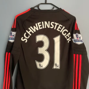 Manchester United Schweinsteiger tröja - Säljer en svart långärmad Manchester United fotbollströja med Schweinsteiger och nummer 31 på ryggen. Tröjan har röda Adidas-ränder längs ärmarna, Premier League-patch på båda armarna och Manchester United-emblem i rött framtill. Materialet är lätt och andas, perfekt för match eller träning.