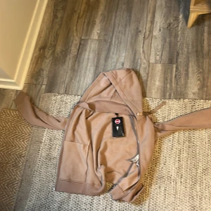 Beige hoodie från Colmar Originals - Jag kan också prata om priset priset är inte fast Den är storlek S har ganska långa armar men ganska kort på längden. Den har aldrig användts. Snygg beige hoodie från Colmar Originals med dragkedja hela vägen, huva med breda snören och två stora fickor framtill. Tröjan har ribbade muddar vid ärmslut och nederkant, samt Colmar-logga på ärmen. Perfekt för chill dagar och streetwear. 