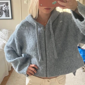 Ljusgrå stickad cardigan jacka med huva - Så mysig och cool blå stickad cardigan jacka med luva och dragkedja framtill. Jackan har ribbade muddar, snörning vid huvan och en loose passform💌💌💌perfekt nu till slutet av sommaren o sen till hösten🥰