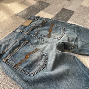 Blåa nudie jeans lean dean  - Lean dean nudie jeans. Storlek oklar men passar mig som har W31 L30. Har några små hål som man kan se på bild