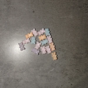 Dekorationer - Säljer ett gäng söta berlocker i form av små björnar i pastellfärger som ljusrosa, ljusblå, ljuslila och ljusbeige. Perfekta att använda till att göra fina naglar.