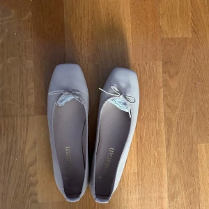 Beige ballerinaskor med rosett - Snygga ballerinaskor från Yvestaran i beige färg med kvadratisk tå och söt rosettdetalj framtill. Skorna är köpta i Barcelona och insåg i Sverige att dem var för små så dem är helt oanvända! 😇💞