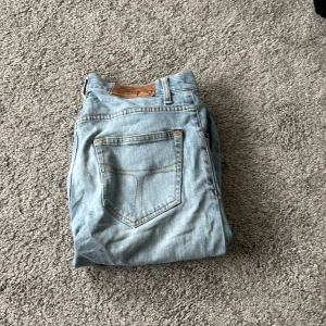 Ljusblå jeans tiger of Sweden, Pistolero 29/32 - Säljer ett par ljusblå jeans från tiger of Sweden modell Pistolero, De har klassisk femficksdesign, raka ben och snygga kontrastsömmar. Jeansen är tillverkade i mjukt denim och har en normal passform som sitter skönt hela dagen.