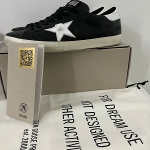 Golden Goose  - Golden Goose i modellen Superstar, en väldigt eftertraktad modell just nu på marknaden med tanken på att det är superstar. Ja vad ska man mer säga om skorna dom är använda 4 gånger och är köpte på NK butiken, lådan dustag, och även golden goose kortet fyller med som ett äktehets bevis. Skorna är i storlek 44 skriv om ni har några funderingar. Annars otroligt bra skick ingen tecken på användning ser ut som sprillans nya.