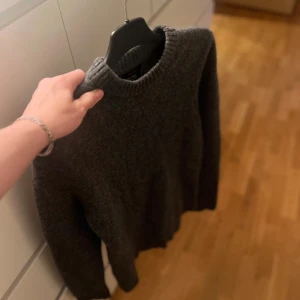 Grå stickad tröja från Massimo Dutti - Snygg grå stickad tröja från Massimo Dutti i ull och kashmir. Klassisk modell med rund halsringing. Knappt använd.