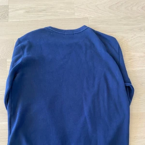 Mörkblå sweatshirt från Polo Ralph Lauren i XL barnst - En klassisk mörkblå sweatshirt från Polo Ralph Lauren. Använd 1 gång säljer den då den är för stor skick 9/10 skulle passa nån som är 160 eller lite längre. Xl i barn storlek men är nog en s i man.