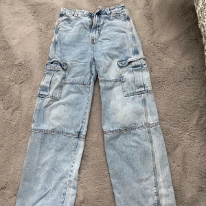 Ljusblå cargopants från Divided - Säljer ett par ljusblå cargopants från Divided med flera stora fickor på sidorna och wide passform vid benen. Väldigt snygga och i bra skick 🩷😻