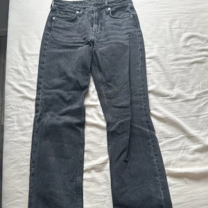 Svarta jeansbyxor med raka ben - Säljer ett par svarta jeansbyxor med klassisk femficksdesign och raka ben. Jeansen har normal passform och är perfekta för en avslappnad stil. Tidlös modell som funkar till många olika outfits.