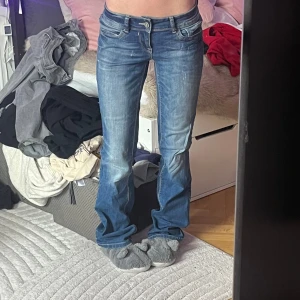 Blåa bootcut / flare jeans lågmidja / low waist / low rise med blekning - Lågmidjade / low waist / low rise bootcut jeans i blå / mörkblå färg med lite ljusare nyans i mitten. Vintage och köpt secondhand🥰 Dm för mått eller andra funderingar 💕kolla in vad mer jag säljer och gör gärna ett bundle och för att få 10% rabatt!☺️