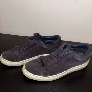 Les Deux mockaskor storlek 42 - Les Deux skor i storlek 42. Mörkblä färg. Skorna är normala i storleken. Producerade i Portugal. Ovansida tillverkad i mocka. Slitsula tillverkad i gummi.