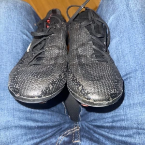 Svarta Nike Phantom fotbollsskor - Säljer ett par svarta Nike Phantom fotbollsskor med snörning och rund tå. Skorna har en stickad ovandel och röda innersulor. Perfekta för dig som vill ha bra grepp och kontroll på planen.   KOM MED BUUUUD