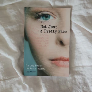 Not Just a Pretty Face: The Ugly Side of the Beauty Industry - Boken 'Not Just a Pretty Face' av Stacy Malkan avslöjar sanningen om kosmetikaindustrin och dess påverkan på hälsa och miljö. Omslaget visar ett ansikte med kemiska ingredienser skrivna över huden. Perfekt för dig som vill veta mer om skönhetsbranschens baksidor.