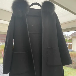 Svart kappa från garoff med äkta päls - En fin kappa från garoff. Köpt för 2500kr men säljer för 900 eftersom den är använd. Den är i okej skick och kan ha några små skavanker. Personligen tycker jag den är i fint skick. Är i storlek XS. Sitter verkligen så fint och passar perfekt!💗kan förhandla  pris även!