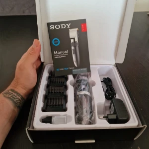 SODY SD 2030 Hårtrimmer - Säljer en SODY SD 2030 hårtrimmer med keramisk titanblad, justerbar längd, och fyra trimmerkammar. Trimmern kan användas både med och utan sladd och har en integrerad detaljtrimmer. Laddare och rengöringsborste ingår.