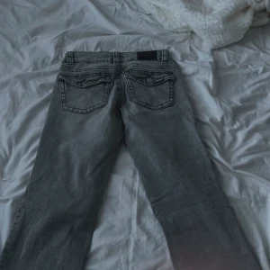 Ljusgråa lågmidjade jeans  - Säljer ett par grå jeans med fickor från Gina, byxorna har inga tecken på användning