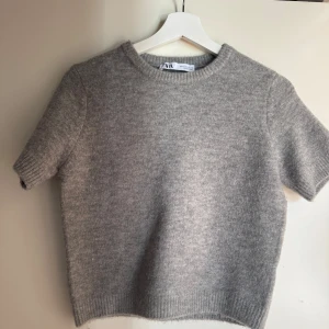 Grå stickad tröja från Zara - Mysig grå stickad tröja från Zara med korta ärmar och rund halsringning. I nyskick🩶🩶