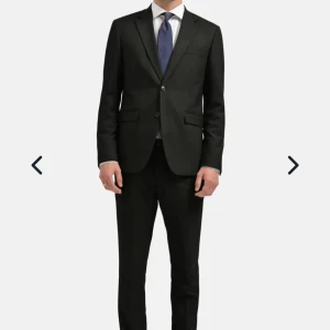 Svart kostym med kavaj och byxor - Kostym från Brothers. Märke Riley. Storlek 50 på kavaj och 48 på byxor.  Köpt för 1799:- på rea Nypris är 2698 och den är använd endast en gång. Passar dig som är ca 180 cm lång.