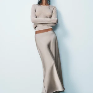 Beige kjol - Säljer en lång ljusbeige kjol från zara i satinliknande material. Säljer då den inte passade men hann inte lämna tbx. Har ingen bild på eftersom den inte passa. Helt ny och oanvänd har dock inte prislapp kvar. Det är samma modell som på första bilden men en annan färg som är slutsåld/ inte säljs längre