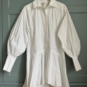 Skjortklänning med ballongärm, student - Säljer min vita skjortklänning från Hm🙌🏻 Klänningen passar så bra till studenten eller andra firanden i vår! Den har fina ballongärmar med knäppning i ärmsluten och är i en oversized modell med vidare kjol från midjan☺️ i stl s men passar mig som annars har m.