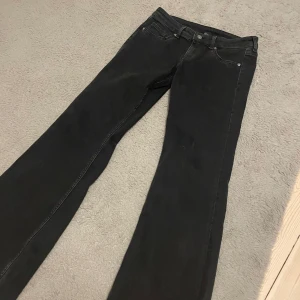 Svarta bootcut jeans - Säljer ett par svarta bootcut jeans. Jeansen har en normal passform och är tillverkade i ett mjukt denimtyg som sitter skönt på kroppen. Perfekta för dig som gillar en Stockholm  stil med lite utsvängda ben.