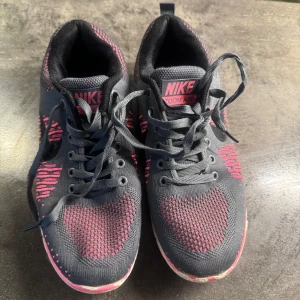 Nike Zoom Air sneakers svart/rosa (pris går o diskuteras) - Säljer ett par Nike Zoom Air sneakers i svart med rosa detaljer och vit sula. Skorna har snörning och är tillverkade i syntetmaterial med stickad ovandel för extra komfort. Perfekta för träning eller vardagsbruk.