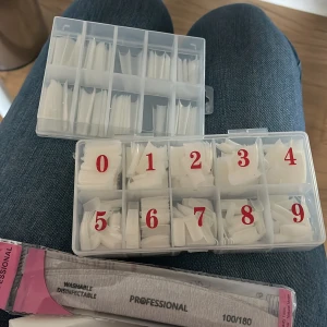 Nageltippar och nagelfilarfrån shein - Säljer ett set med vita nageltippar i olika storlekar, sorterade i en plastask med siffror 0-9. Medföljer gör även nagelfilar, 100/180 grit, perfekta för att forma och fila naglarna. Perfekt för dig som gillar att fixa naglarna hemma.