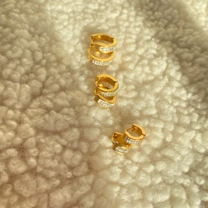 Guldiga örhängen med stenar - Säljer flera par guldiga örhängen i olika storlekar, vissa med glittriga stenar. Perfekta för att mixa och matcha till din stil. Snygga och trendiga hoops som ger en lyxig känsla. Rostfritt 