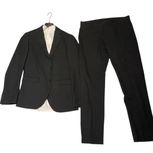 Svart kostym med skjorta  - Svart kostym och skjorta i mycket bra skick, inga defekter eller så. Säljer då den inte passar mig längre. Kommer med vita skjortan som är storlek M, slim fit. Kavajen är storlek 48 och kostym byxorna är storlek 50.