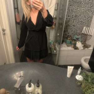 Svart klänning - Snygg svart klänning med v-ringad design och långa ärmar. Köpt från Zara och använd Max 5 gånger så skulle absolut säga nyskick🥰det är smuts på spegeln inte klännings!!!