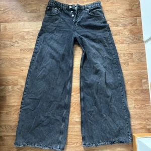 Svarta wide leg jeans från Ginatricot  - Säljer ett par svarta wide leg jeans från Ginatricot Jeans med medelhög midja och slitna kanter nertill. Jeansen har knäppning med flera knappar framtill. De är i väldigt bra skick då jag knappt använt dem! 😍