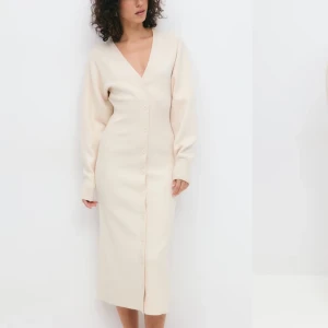 Beige långklänning med v-ringning - Från Gina Tricot Användes två gånger så den är helt ny, nypris 599kr. Säljer en beige långklänning med v-ringning och långa ärmar. Klänningen har knappar längs hela framsidan. Perfekt att styla både som klänning eller öppen över jeans. Passa både som XS och S