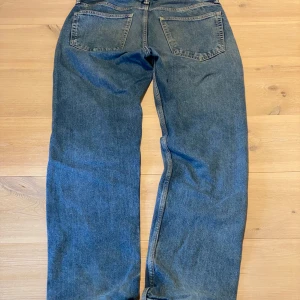 Blå raka jeans - Klassiska blå jeans med raka ben och femficksmodell. Jeansen har normal passform och är tillverkade i ett slitstarkt denimtyg. Perfekta för en avslappnad stil. Skicka ett meddelande för frågor, storlek, mått osv. 