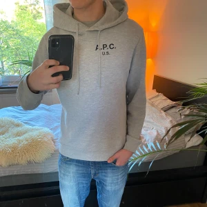 Ljusgrå hoodie från A.P.C. - Säljer en sjukt snygg och stilren ljusgrå hoodie från A.P.C. med svart tryck på bröstet. Denna extremt eftertraktade hoodie har huva med original snören och långa ärmar. Perfekt för en avslappnad look och passar till det mesta hela året om. Tillverkad i USA, Kalifornien. Hoodien har minimala täcken på användning och befinner sig i skicket 9.5/10. Nypriset ligger runt 3000 kronor. Tveka inte på att höra av dig vid frågor eller funderingar! ⭐️