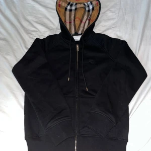 Svart burberry zip hoodie - Säljer nu en svart burberry zip hoodie. Jag har endast använt den ett fåtal gånger och säljer den nu eftersom den är väldigt liten i storleken, mer som S istället för M. Det finns inga skador eller annat på den. Vid mer frågor eller liknande är det bara att skicka iväg ett meddelande. Priset kan diskuteras vid snabb affär.