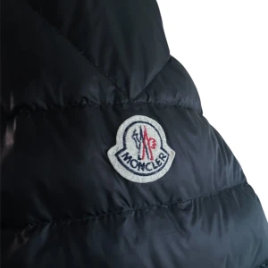 Moncler Daniel Down  - Säljer en svart dunjacka från Moncler med quiltad design och dragkedja framtill. Jackan har Moncler-logga på bröstet och randiga detaljer vid dragkedjorna. Perfekt för kyliga dagar.