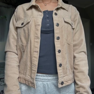 Beige manchesterjacka med knappar - Säljer en beige manchesterjacka med klassisk krage och svarta knappar framtill. Köpt från Jacqueline de YOUNG för 749kr och knappt använd. 