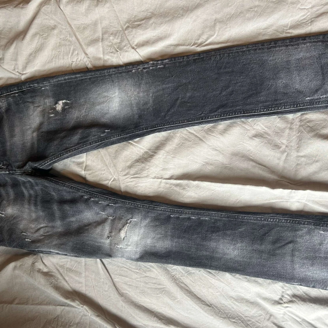 Grå slitna jeansbyxor