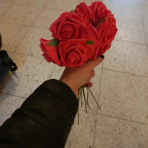 Röd rosformad sminkborste - Säljer en unik sminkborste formad som en röd ros med gröna blad. Borsten har ett långt, smalt handtag i metall och själva borstdelen är formad som blomblad. Perfekt för att applicera puder eller rouge och en snygg detalj i sminksamlingen.