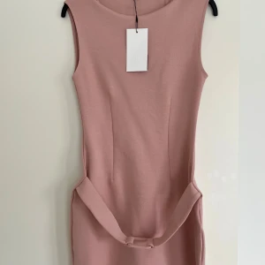 Rosa ärmlös klänning med bälte - Superfin rosa kort klänning med ett bälte i midjan. Från Zara! Aldrig andvänt och prislappen kvar! Den är i storlek M men passar bra som en S!