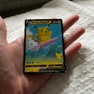 Surfing Pikachu V Pokémonkort - Unikt Pokémonkort med Surfing Pikachu V. Kortet har en färgglad design med Pikachu på en rosa surfbräda och blå bakgrund med bubblor. Perfekt för samlare eller Pokémon-fans som vill utöka sin samling.