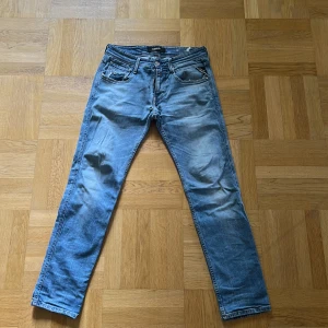 Blå Replay Anbass jeans  - Säljer ett par använda replay jeans köpta på nk. Dem har mindre slitningar vid skrevet, hålet visas på bilderna. Storlek Length 30 Waist 28