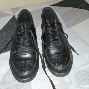 Svarta sneakers med snörning - Svarta sneakers med klassisk design och snörning. Skorna har rund tå, platt sula och perforerade detaljer framtill för extra ventilation. Passar perfekt till vardags och har en stilren look.