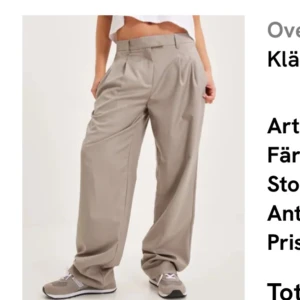 Beiga oversized kostymbyxor - Säljer ett par beiga kostymbyxor med oversized passform och vida ben. Byxorna har hög midja, pressveck och klassisk kostymstil. Perfekta att styla med sneakers eller klackar för en trendig look.